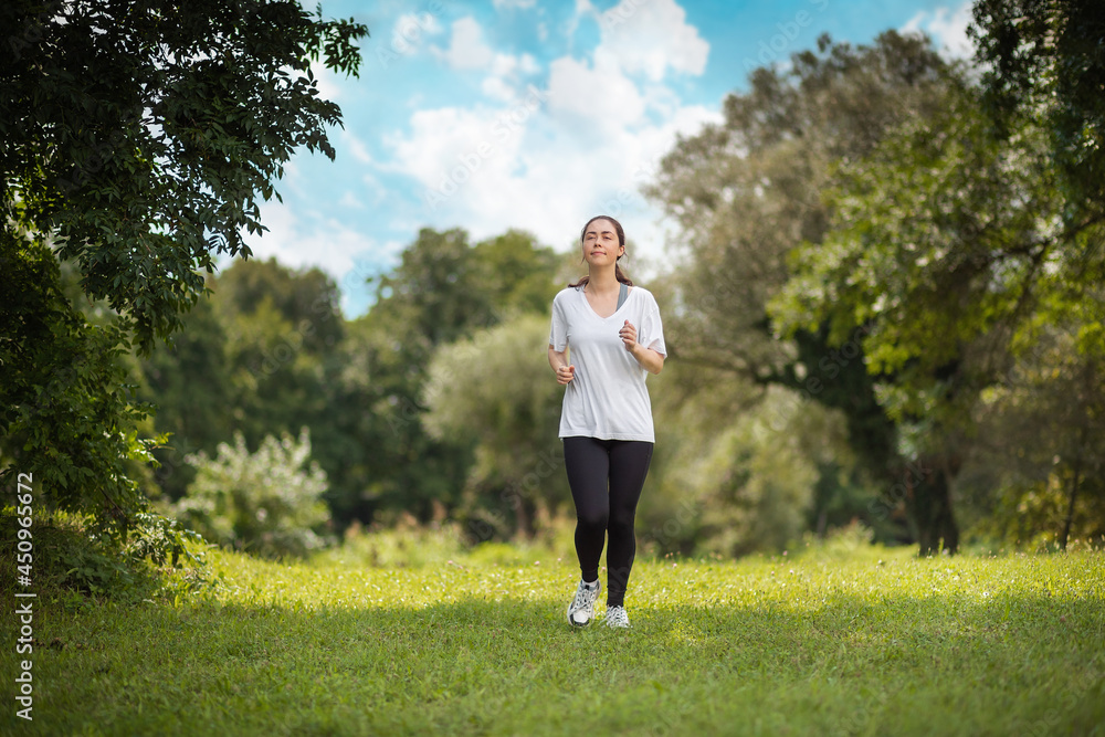Fitness and wellness. A young caucasian athletic woman is jogging in the park Fitness and wellness. A young caucasian athletic woman is jogging in the park