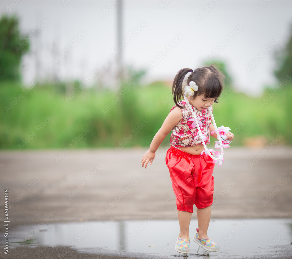 Close-up background view of a blurred Asian girl running or teasing in the street in front of the house, doing activities together outside the classroom during the holidays. Close-up background view of a blurred Asian girl running or teasing in the street in front of the house, doing activities together outside the classroom during the holidays.
