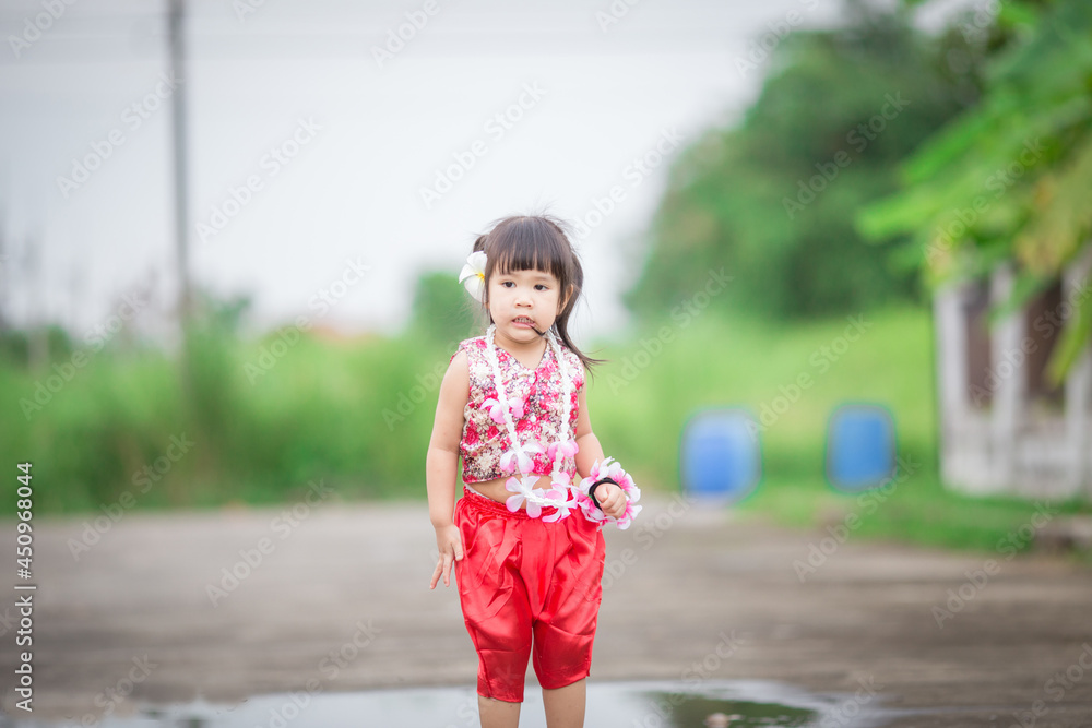 Close-up background view of a blurred Asian girl running or teasing in the street in front of the house, doing activities together outside the classroom during the holidays. Close-up background view of a blurred Asian girl running or teasing in the street in front of the house, doing activities together outside the classroom during the holidays.