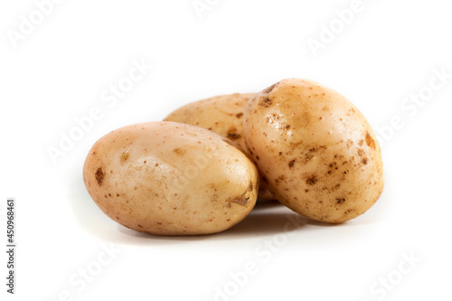 Three fresh white potatoes on a white background
