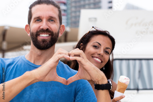 Closeup of couple making heart shape with hands.