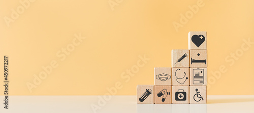 Wooden block with healthcare medical icons orange pastel background. stacking wooden cube box medical. healthcare treatment concept.