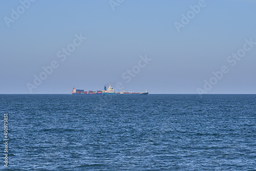 Beautiful evening view of cargo and container ships in the Irish Sea seen from West Pier of Dun Laoghaire harbor, Dublin, Ireland. Soft and selective focus. Minimalism © Romio Shots