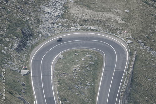 Motorcycle riding on twisted road in the mountains aerial view transfagarasan romania