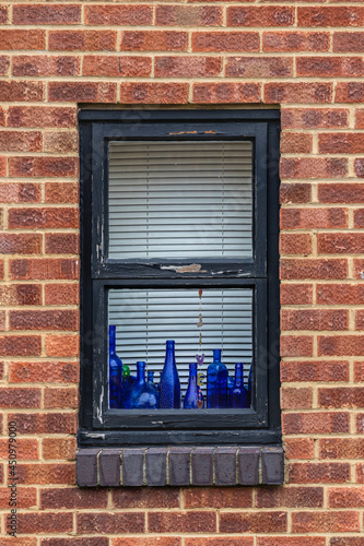 window on brick wall with blue bottles