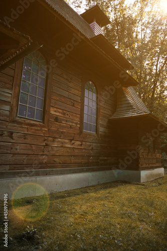 ancient wooden church outskirts park outdoor wilderness environment space sunny time with light glare fall season September day vertical photography