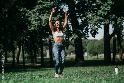 smiling woman with headphones performing fitness exercises in a