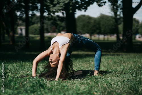 athletic young woman performing a bridge exercise outdoors.