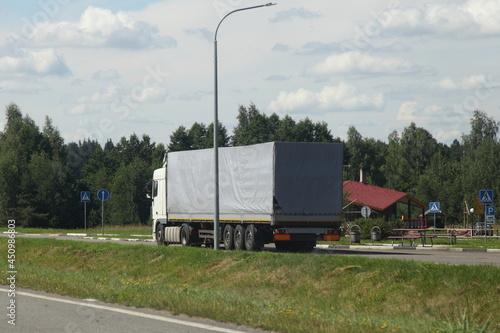 One European tented truck parked near a roadside cafe camping at Sunny summer day, cargo safety on the parking and when the driver is resting © Ilya