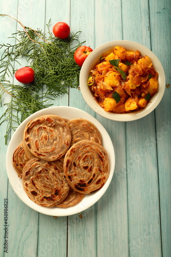 Indian vegetarian meal- homemade wheat paratha served with potato masala curry.  photo