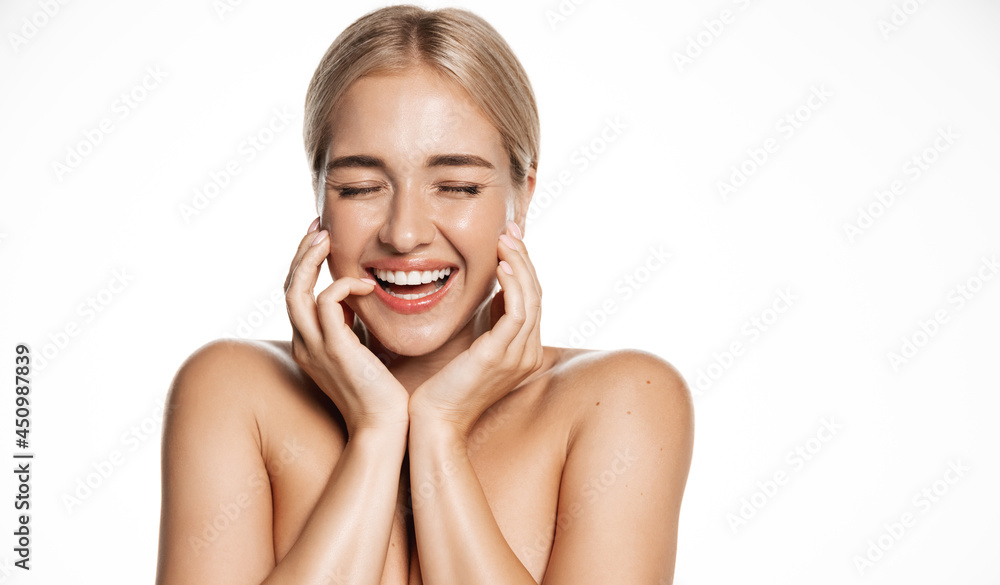 Beauty face. Smiling blond woman touching healthy skin portrait. Beautiful happy girl model with fresh glowing hydrated facial skin and natural makeup on white background at studio. Skin care concept Beauty face. Smiling blond woman touching healthy skin portrait. Beautiful happy girl model with fresh glowing hydrated facial skin and natural makeup on white background at studio. Skin care concept