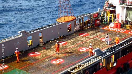 Workers are lifted by the crane to the offshore platform, Transfer crews by personal basket from the platform to crews boat.