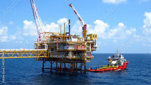 Supply boat transfer the cargo for supporting oil and gas industry and moving cargo from the boat to the platform. Boat is waiting transfer cargo and crews to platform.