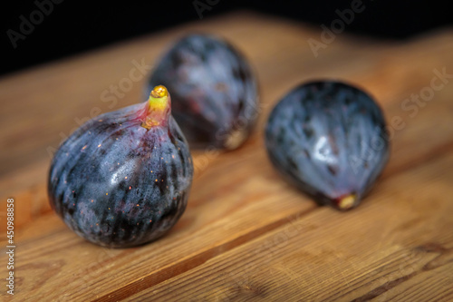 Fresh purple figs on a wooden background from old boards. Raw exotic figs. Low key