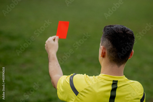 Referee showing a red card to a displeased football or soccer player while gaming. Concept of sport, rules violation, controversial issues, obstacles overcoming.