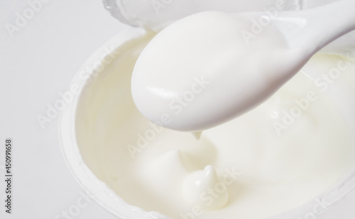 sour cream in bowl and spoon, mayonnaise, yogurt, isolated on white background, clipping path, full depth of field