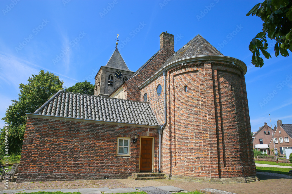 Obraz premium View on one of the oldest dutch romanesque protestant church from 10th century in the flood plains of rhine area against blue summer sky - Oude Kerk in Osterbeek - Wolfheeze, Gelderland, Netherlands