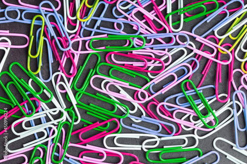 Multicolored paper clips scattered as textured background