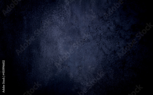 Dark blue textured concrete background with center light spot . Abstract texture for graphic design or wallpaper