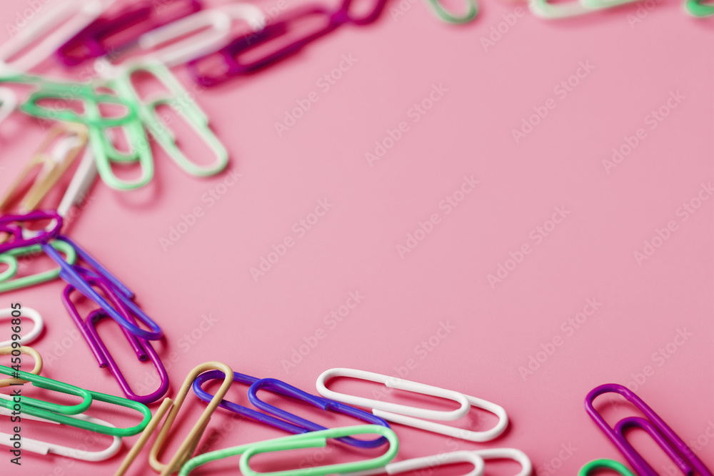 Multicolored rzhivtkzhtsrbt Paper clips scattered on a pink background Multicolored rzhivtkzhtsrbt Paper clips scattered on a pink background