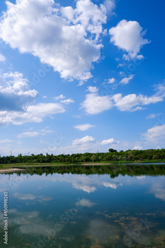 Beautiful summer landscape. Sky, clouds, lake. Mirror the sky and trees in the lake. Good screensaver or wallpaper. © Iryna