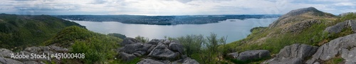 Female hiker setting on mountain top looking onto fjord and city Downtown in Stavanger Norway © FreezeFrames