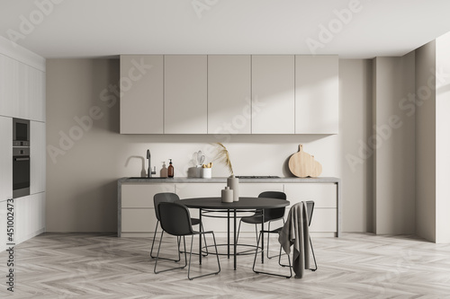 Simple light beige kitchen with round black dining table
