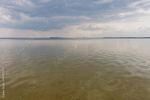 Reflection of clouds in the lake. Small waves on the surface of the water. Summer © Roman