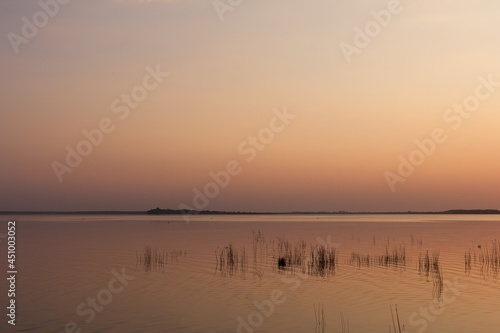 Fototapeta Naklejka Na Ścianę i Meble -  Sunset on the lake. Evening sky with beautiful clouds is reflected in the water of the lake