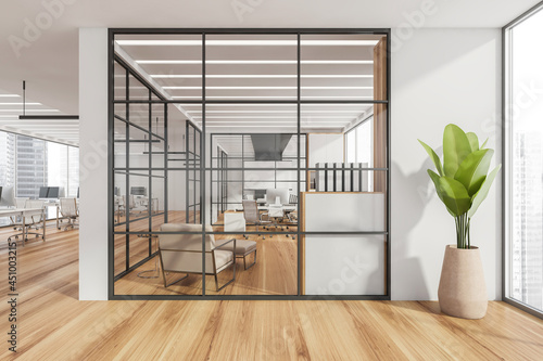 White open space with a conference room behind glass partition walls