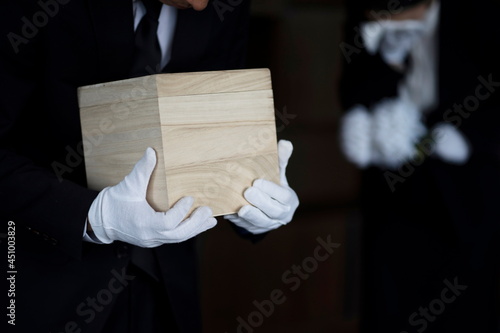 Bereaved holding urn at funeral