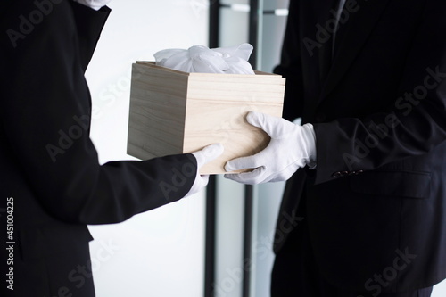 Fotografía Bereaved holding urn at funeral