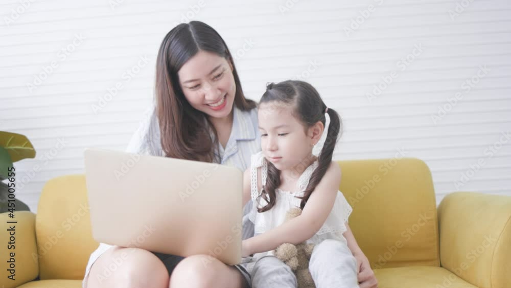 Active Asian mother and daughter study online from tablet in living room home. Entertainment activities family holidays. online teaching technology. Stay at home. quarantine during country lockdown Active Asian mother and daughter study online from tablet in living room home. Entertainment activities family holidays. online teaching technology. Stay at home. quarantine during country lockdown