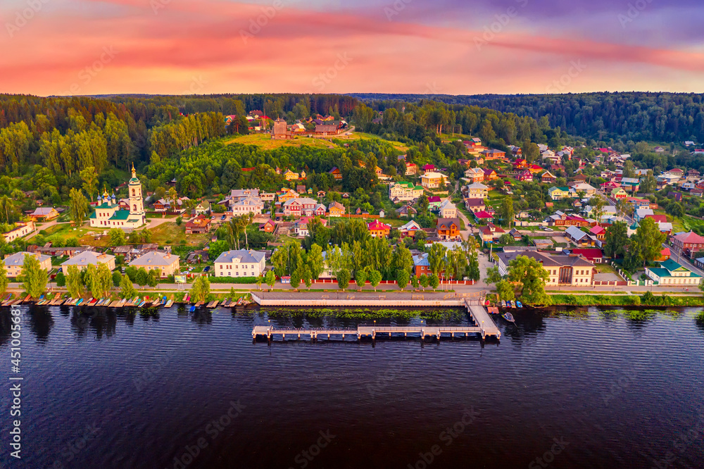 Fototapeta premium Aerial drone view of ancient russian town Ples on the Volga river with colorful sunset