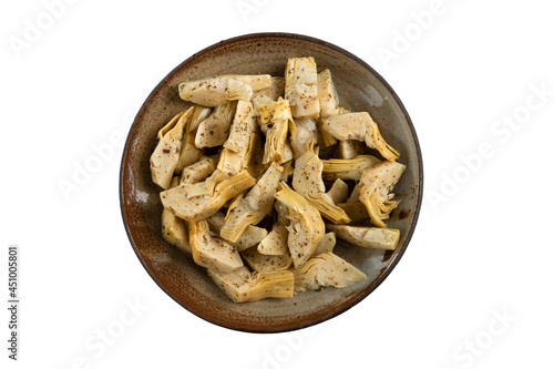 Marinated parts artichoke in oil with herbs. Artichoke in a bowl with clipping path on a white background.