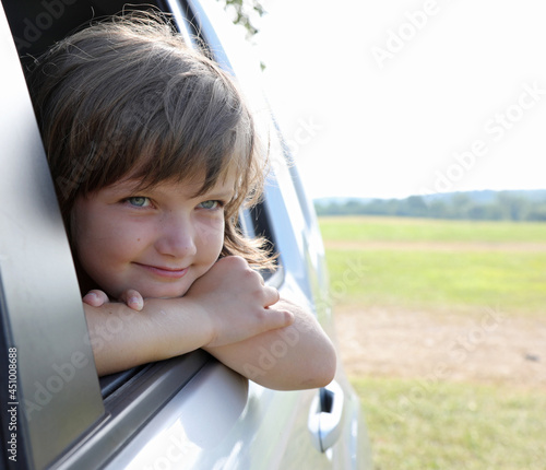 Caucasian girl looking out the car's open window. photo