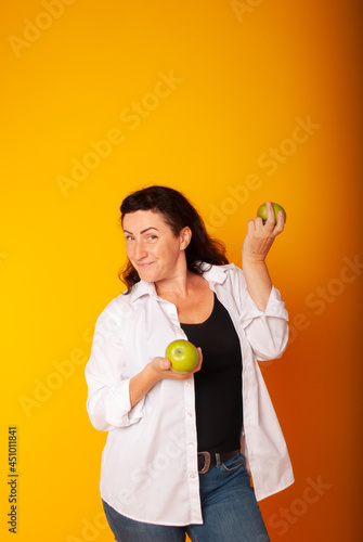 woman on a yellow background with apples in her hands, slimming. healthy lifestyle. Vegan day. © Marina Chernivetskay