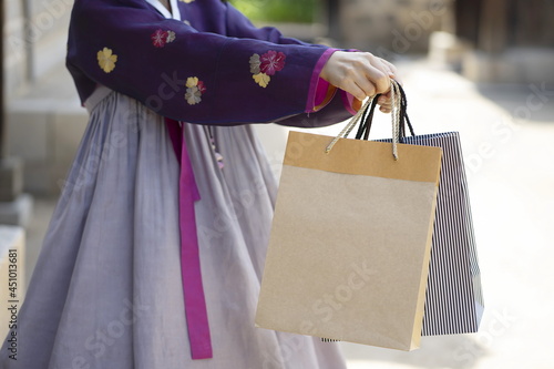 Woman in Korean traditional clothes holding shopping bags
