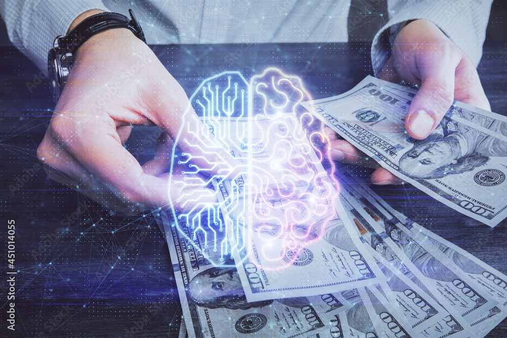 Multi exposure of brain drawing hologram and us dollars bills and man hands. Ai invest concept Multi exposure of brain drawing hologram and us dollars bills and man hands. Ai invest concept