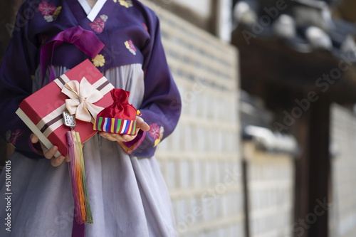 Woman in Korean traditional dress holding lucky bag with gift box