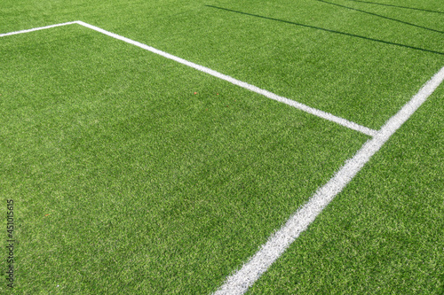 Soccer football background. Green synthetic artificial grass soccer sports field with white stripe lines