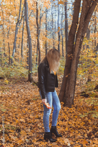 Young woman holding autumn leaves in fall park. Seasonal, lifestyle and leisure concept. © satura_