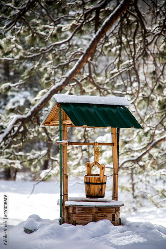 Snow collects on a wishing well during a sunny winter day in Bailey, Colorado following a blizzard. photo