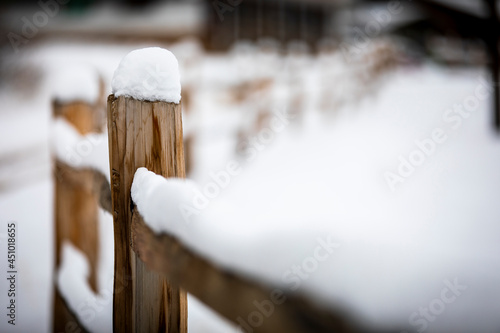 Several inches of snow collects on top of a wooden split rail fence on a cold winter day in Bailey, Colorado. photo