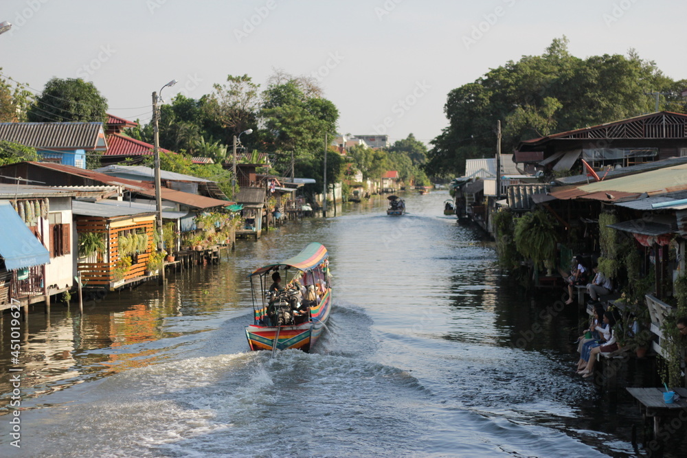 Obraz premium a small canal of a Thai village in Bangkok and a boats traveling.
