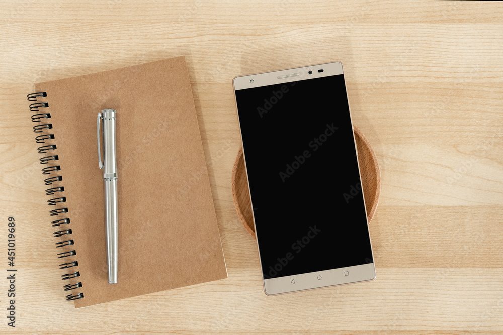 Tablet, notebook and pen in brown color, on wood background. Office style. Tablet, notebook and pen in brown color, on wood background. Office style.