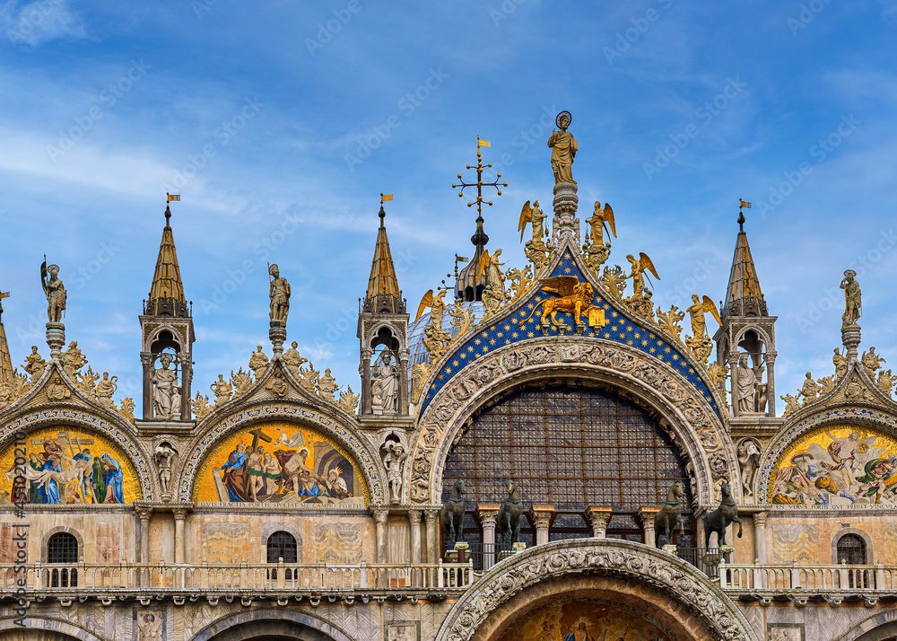 Details of main facade of St Mark's cathedral in Venice. Italy. UNESCO World Heritage city, blue sky, clouds, mosaics, carvings, sculptures, pinnacles Details of main facade of St Mark's cathedral in Venice. Italy. UNESCO World Heritage city, blue sky, clouds, mosaics, carvings, sculptures, pinnacles
