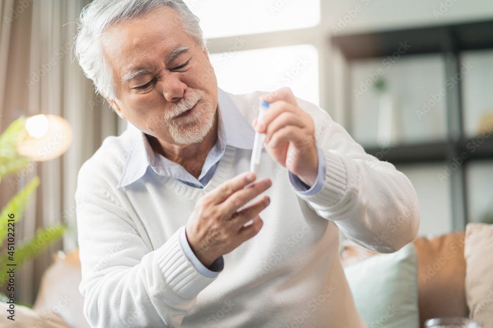Old senior asian male hand nasal swab testing rapid tests by himself for detection of the SARS co-2 virus at home isolate quarantine concept Old senior asian male hand nasal swab testing rapid tests by himself for detection of the SARS co-2 virus at home isolate quarantine concept