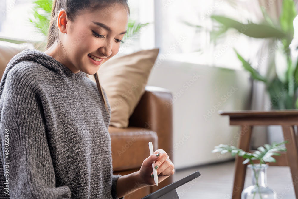 young attrative asian female working at home hand use tablet checking businesss data chart planning report with leisure relax on sofa in living room home isolate concept young attrative asian female working at home hand use tablet checking businesss data chart planning report with leisure relax on sofa in living room home isolate concept