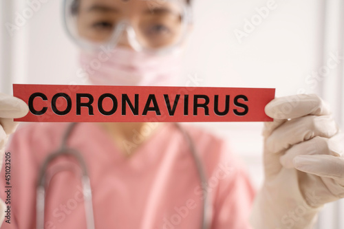 Doctor showing paper with coronavirus text 